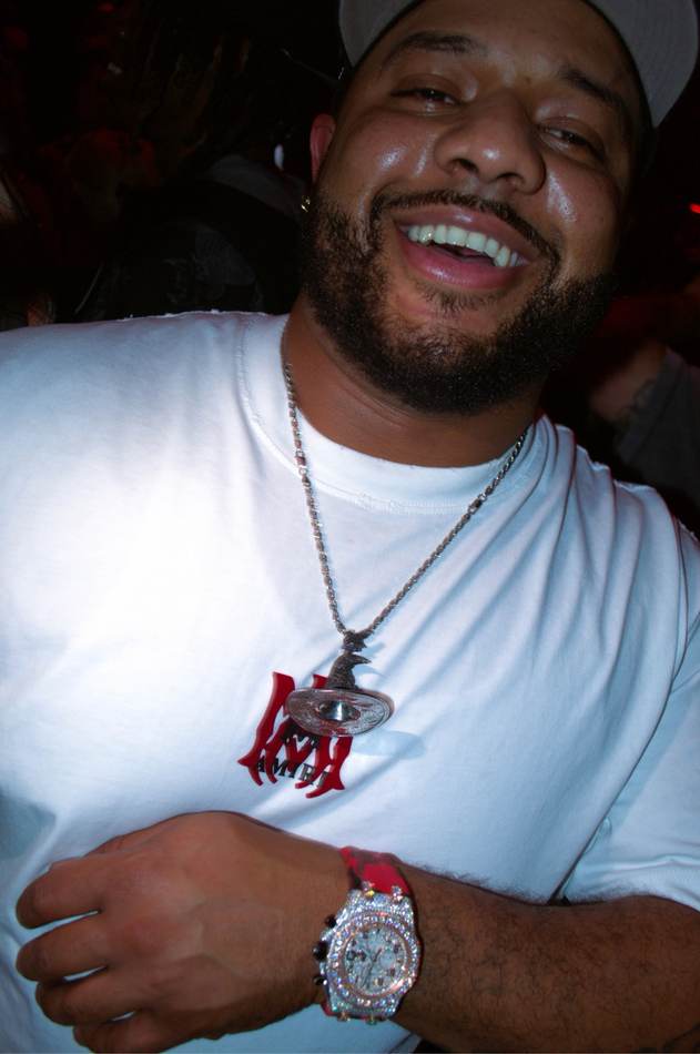 Happy client wearing a Mars Jewelers pendant and iced watch