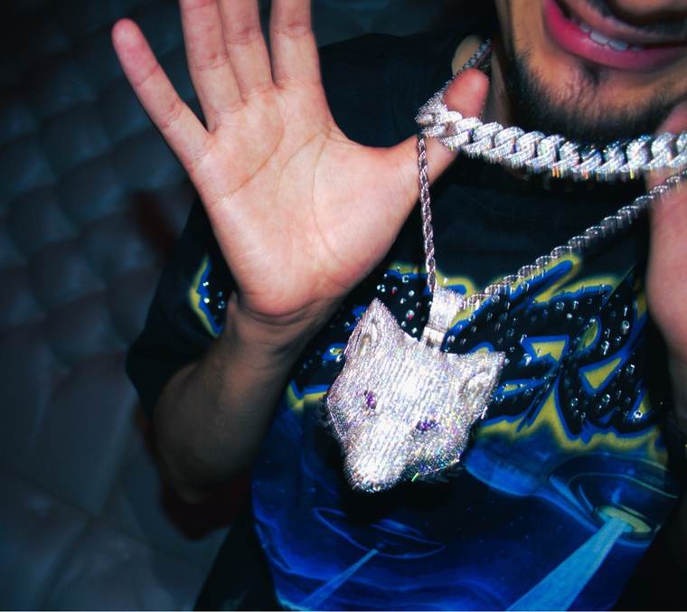 The iced wolf pendant held up close